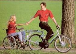 Persona in bicicletta che traina una persona in carrozzina