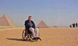 Uomo in carrozzina davanti alle Piramidi in Egitto