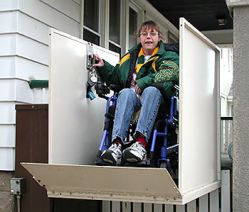 Donna con disabilità su montascale per entrare in casa