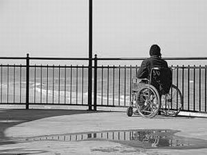 Persona con disabilità guarda il mare da una terrazza (foto in bianco e nero)