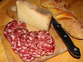 Coltello, pane, formaggio e salame su un tagliere