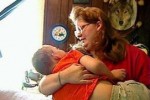 Una madre tiene in braccio il figlio, affetto da una Malattia Rara