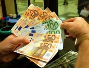 Particolare di mani che contano vari euro