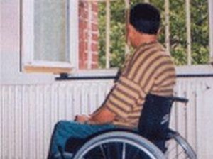 Uomo con disabilità davanti a una finestra con grata