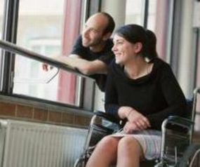 Giovane donna con disabilità alla finestra insieme a un amico