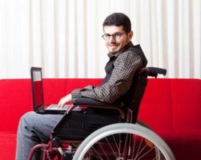 Giovane con disabilità con un computer sulle gambe