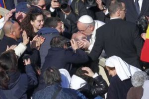 Papa Francesco bacia una persona con disabilità