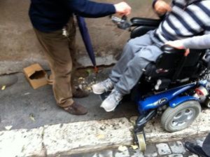 Carlo, giovane con disabilità, in un marciapiede di Roma