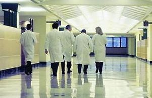 Medici fotografati di spalle in un corridoio di ospedale