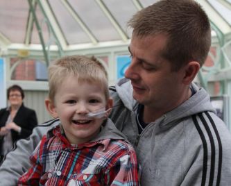 An English child suffering from a rare disease with his father