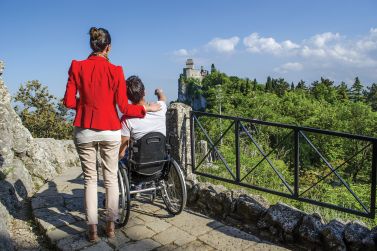 Persona con disabilità davanti alla Rocca del Titano di San Marino
