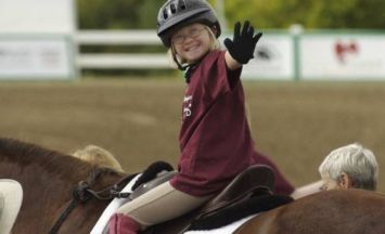 Giovane persona con disabilità in sella a un cavallo