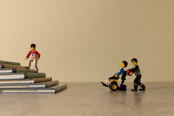 Realizzazione grafica con pezzi di Lego (gli omini non disabili e uno in carrozzina) e libri (le scale)