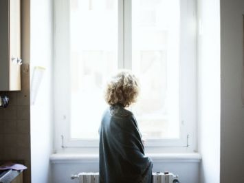 Donna di spalle davanti a una finestra