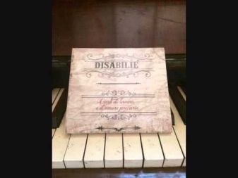 Copertina di "Canti di lavoro e d'amore precario" dei Disabilié!, sopra i tasti di un pianoforte