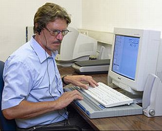 Persona con computer con riga braille e sintesi vocale