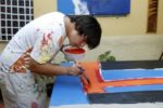 Il giovane artista brasiliano Lucio Piantino, persona con sindrome di Down, al lavoro su una sua opera