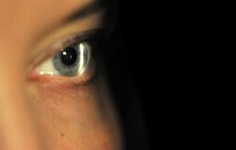 Occhio di donna con un riflesso di luce in verticale