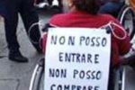La protesta di una persona con disabilità di Bergamo contro le barriere degli esercizi commerciali