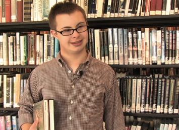 Giovane con disabilità intellettiva in una biblioteca
