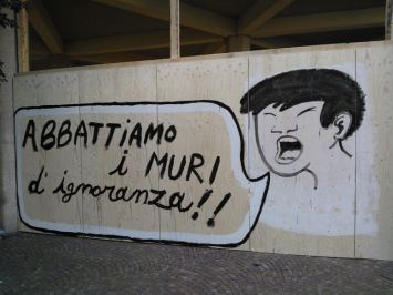 Murale con la scritta "Abbattiamo i muri dell'ignoranza"