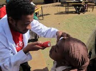 Operatore di CBM impegnato in prevenzione tracoma con bambina