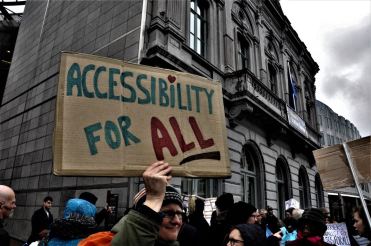 Persona con cartello recante la scritta "Accessibility for All"