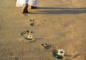 Piedi lasciano orme sulla sabbia. Sulle orme dei fiori