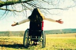 Giovane donna con disabilità a braccia aperte, fotografata di spalle