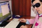Una giovane persona con disabilità visiva al computer