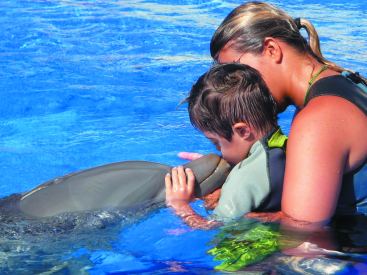 Delfino, bimbo con sindrome di Down e istruttrice al Parco Acquatico Aqualand di Adeje in Spagna