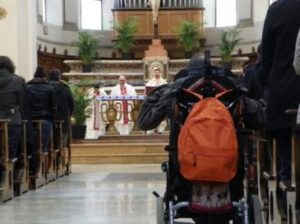 Persona con disabilità in carrozzina in chiesa durante la Messa