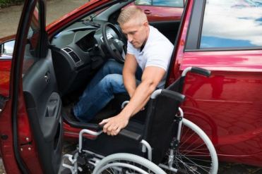Persona con disabilità in motore che sale in auto