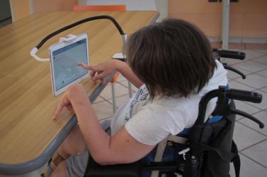 Persona con disabilità motoria al lavoro su un tablet