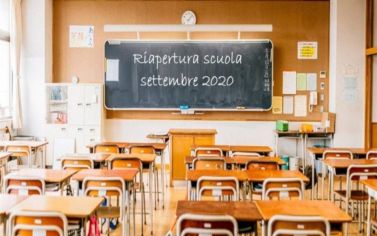 Aula vuota con lavagna recante la scritta "Riapertura scuola settembre 2020"