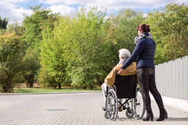 Persona anziana con disabilità insieme all'accompagnatrice