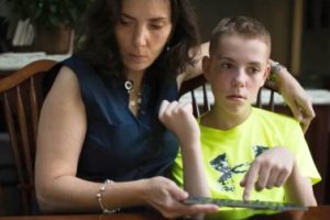 Una donna caregiver familiare insieme al figlio, ragazzo con disturbo dello spettro autistico