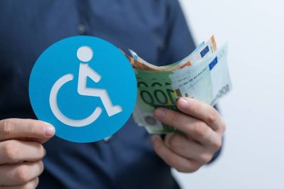Persona con soldi e logo disabilità in mano