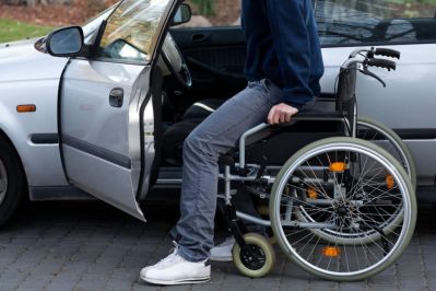 Persona con disabilità in carrozzina sale in macchina
