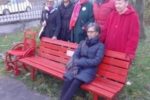 Alcune volontarie della UILDM di Bergamo con la panchina rossa e la carrozzina rossa installate il 25 novembre
