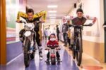 Vanni Oddera (a sinistra), considerato il "padre" della "mototerapia" in Italia, in un corridoio di ospedale insieme a un bimbo e a un ragazzo