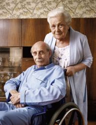 Uomo anziano in carrozzina insieme a una donna anziana