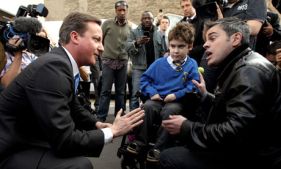 Il primo ministro inglese David Cameron parla con il padre di un bimbo con disabilità, durante la campagna elettorale