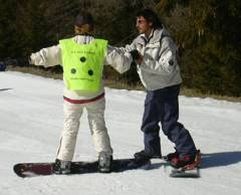 Il pettorale giallo con dischi neri (qui usato in un'attività di snowboard) è il simbolo distintivo internazionale degli sciatori ciechi