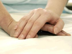 Una mano sopra alla mano di una persona malata. Immagine che simboleggia le cure palliative e la terapia del dolore