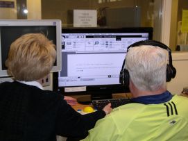 Due persone anziane al computer, l'uomo con disabilità