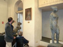 Persona con disabilità in visita a un museo insieme a un accompagnatore