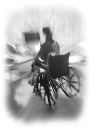 Immagine in bianco e nero, sfuocata, di una persona in carrozzina al computer