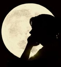 Ombra di donna di profilo davanti a una luna piena