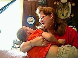 Bimobo con gravissima disabilità in braccio alla madre